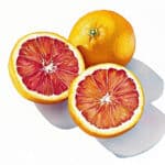 Orangen und Blutorangenhälften auf weissem Hintergrund