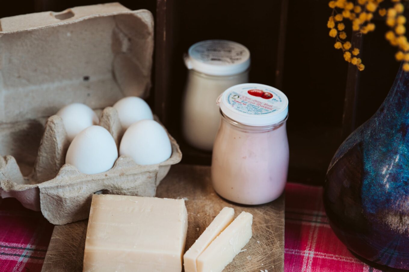 Eier, Käse, Joghurt auf Holzbrett