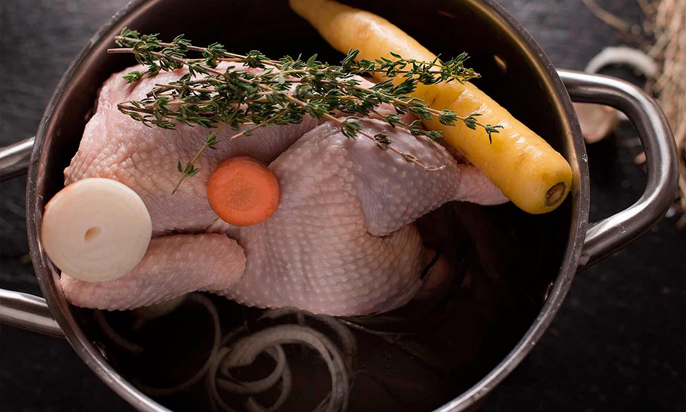 Huhn im Topf mit Gemüse und Kräutern