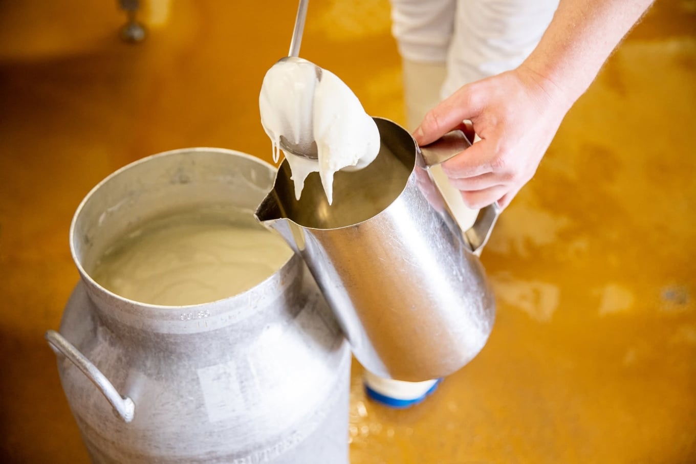 Frischer Joghurt wird in der Chäs-Hütte Rust mit Kelle in Kanne geschöpft