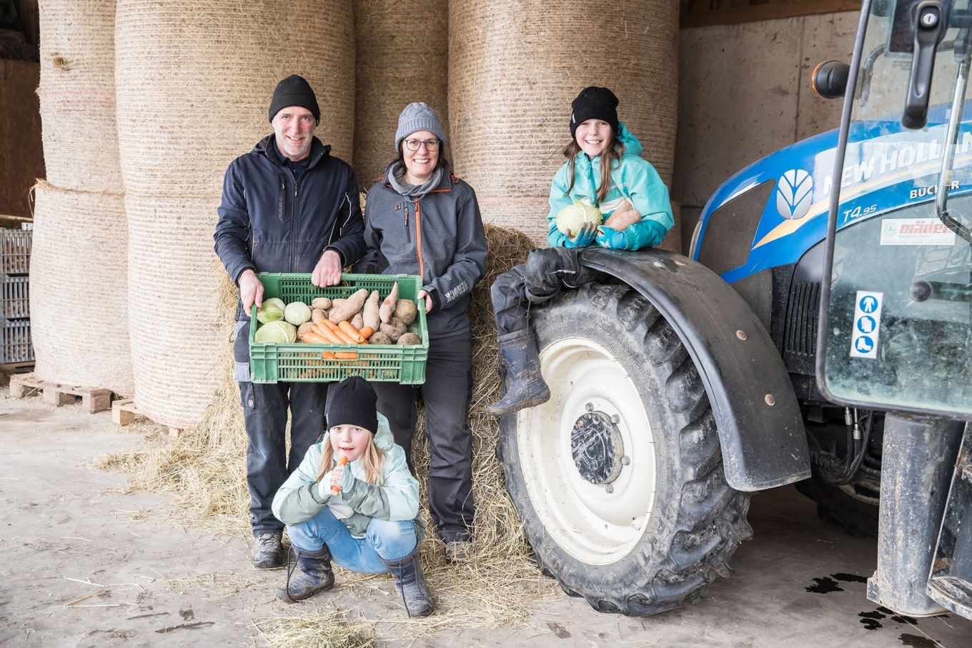 Bauern-Familie Kohler vom Trottenhof mit Gemüsekorb vor Traktor