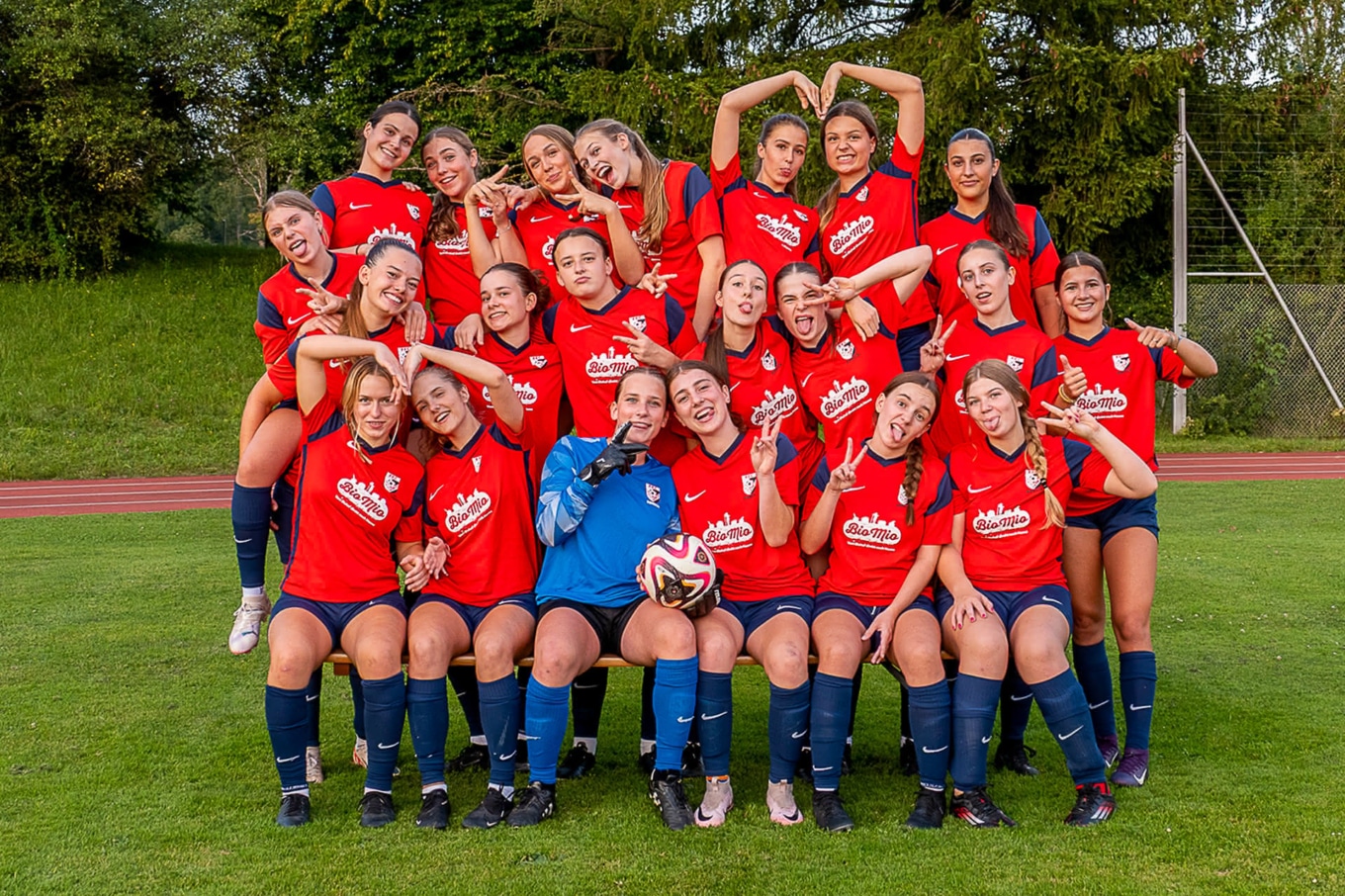 Fussballteam des FFC Südost posiert auf einem Sportplatz